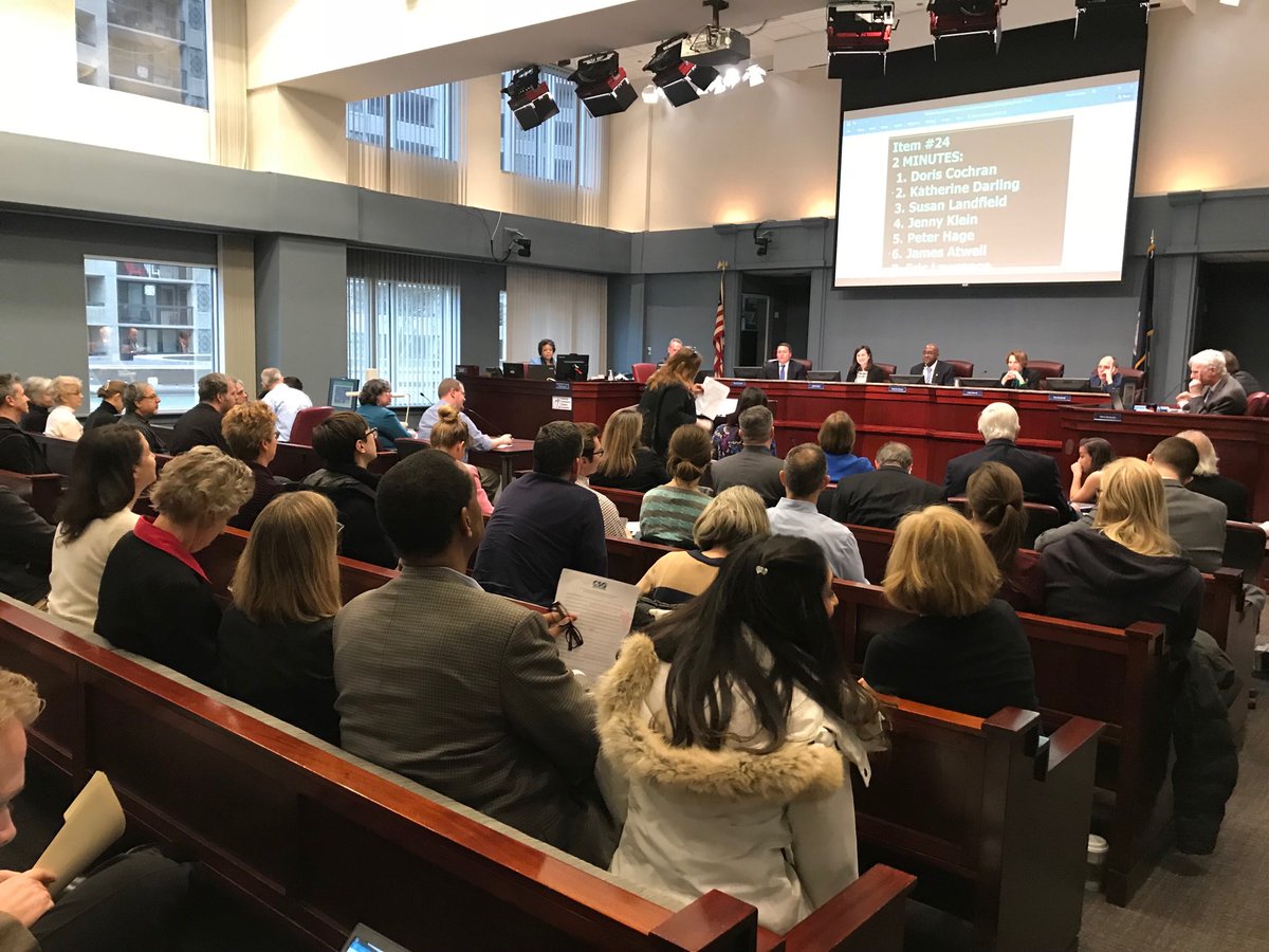 Large group attending a public meeting in a government building.