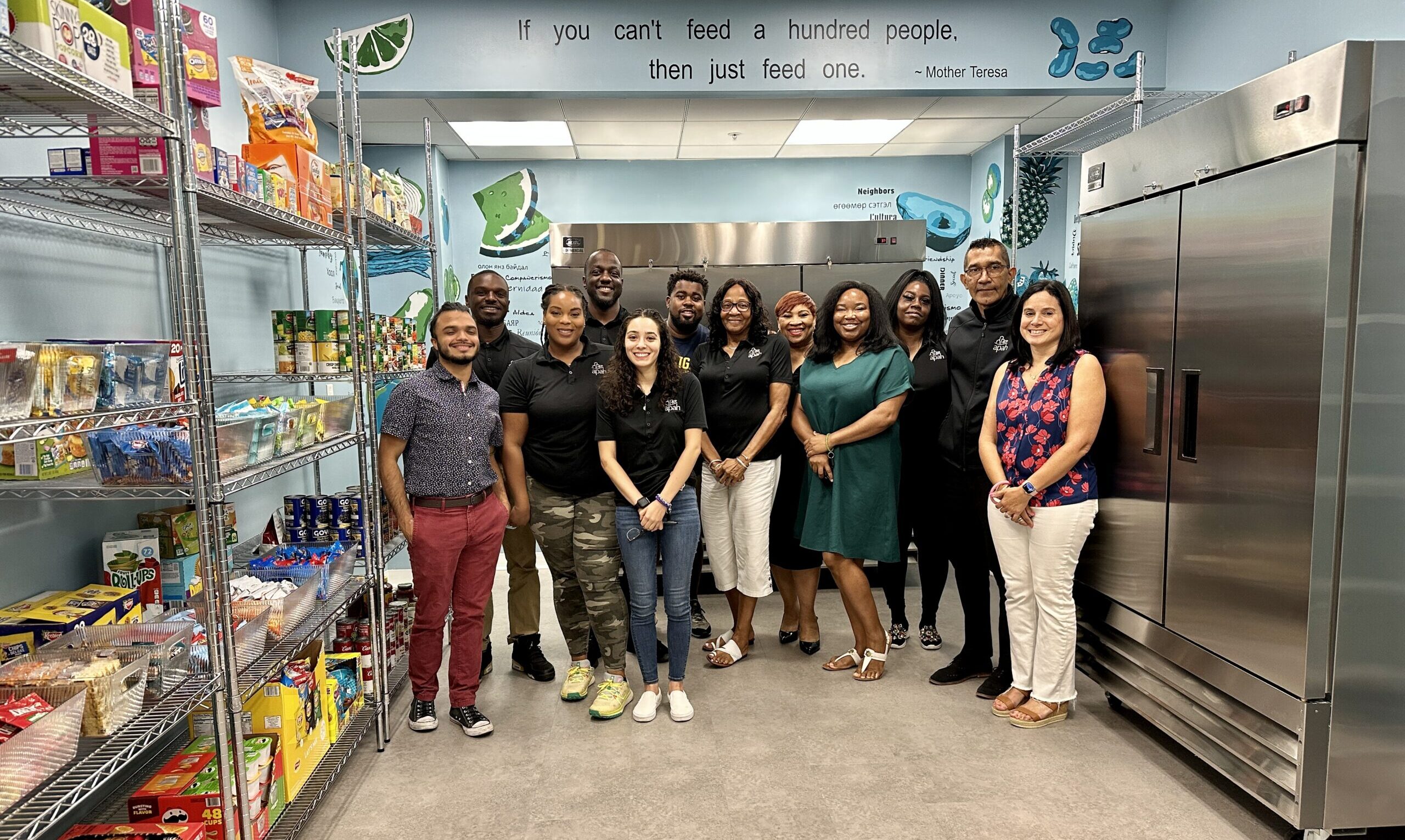 Group of workers smiling for the photo, pantries full of sweets can be seen all around.