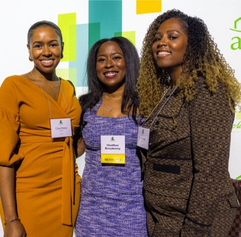 Three women smiling in front of a backdrop with "apah" and "Celebrate Home!" logos.