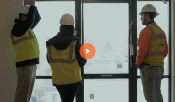 Screenshot of a video showing workers dressed in safety suits.