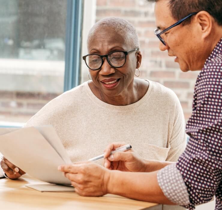 Older woman reviewing documents with a man while smiling and discussing details