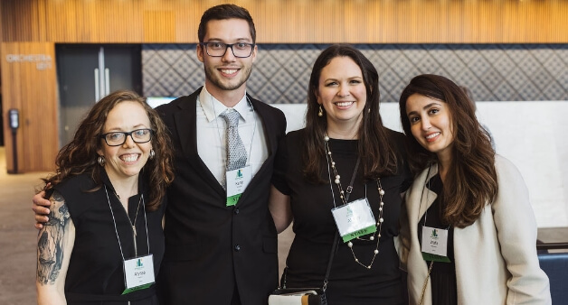 Group of four professionals smiling at a conference or networking event